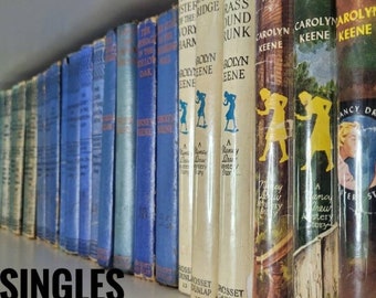 May include: A shelf full of vintage paperback books with blue and white covers. The books are all by Carolyn Keene and feature the text "Nancy Drew Mystery Story" on the spines. The books are arranged in order of publication date.