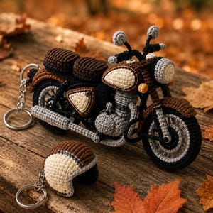 Puede incluir: Un llavero de motocicleta tejido a ganchillo con un marco marrón y negro con detalles en color crema, un faro redondo y un motor detallado. Un llavero de casco tejido a ganchillo a juego en marrón y crema se encuentra junto a la moto.