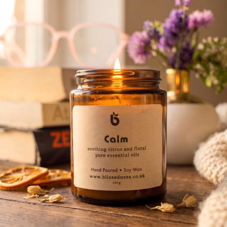 Lit Calm aromatherapy candle in amber glass jar
