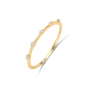 May include: A thin yellow gold ring featuring four small, clear, round-cut stones set along the top half of the band. The interior of the band is clearly stamped with the number 585, indicating the gold purity of the metal ring.