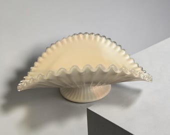 Il s'agit d'un bol sur pied en verre de lait Fenton Art Glass Silver Crest avec un bord transparent à volants.