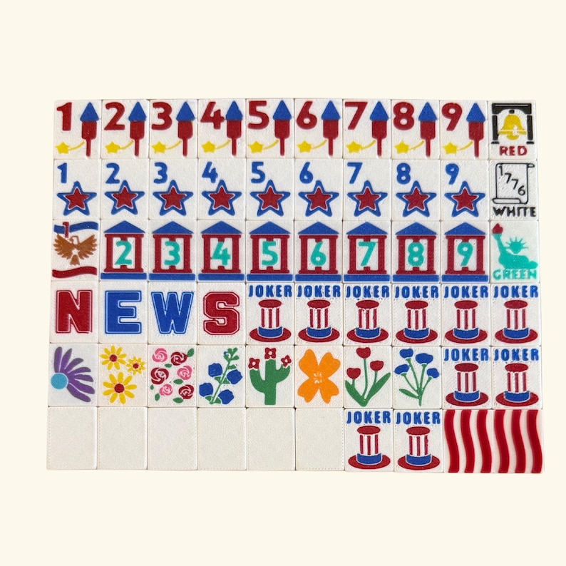 May include: A set of rectangular mahjong tiles featuring various designs including numbers one through nine, stars, patriotic symbols, flowers, the word NEWS, and JOKER tiles. The tiles display red, white, blue, green, and yellow graphic illustrations.