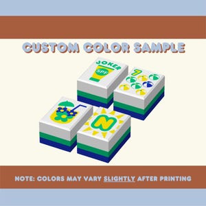 Puede incluir: Cuatro bloques rectangulares con varios dise&ntilde;os y texto, incluyendo "JOKER SPF" y "N". Los bloques tienen tapas blancas, secciones intermedias verdes y azules, y est&aacute;n etiquetados como "CUSTOM COLOR SAMPLE". Tambi&eacute;n est&aacute; presente el texto "NOTE: COLORS MAY VARY SLIGHTLY AFTER PRINTING".