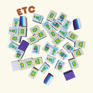 May include: A collection of white and yellow tiles with various summer-themed illustrations, including sunscreen, flowers, and suns. Some tiles feature the word "JOKER" and letters. The word "ETC" is in the top left corner. Several purple and white blocks are also present.