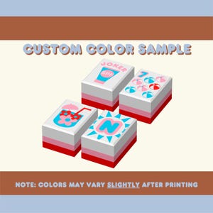 Puede incluir: Cuatro bloques rectangulares con varios dise&ntilde;os y el texto "CUSTOM COLOR SAMPLE". Los bloques tienen tapas blancas, bordes rosas y rojos, y presentan im&aacute;genes de una bebida, protector solar, pelotas de playa y la letra "N". Tambi&eacute;n est&aacute; presente el texto "NOTE: COLORS MAY VARY SLIGHTLY AFTER PRINTING".