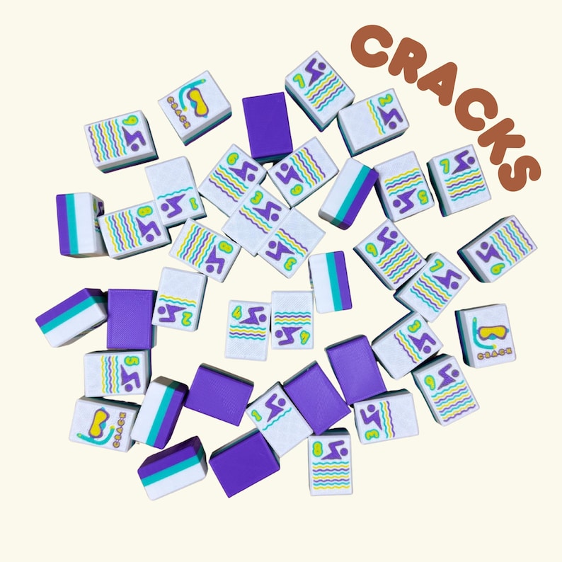 May include: A collection of white, purple, and teal Mahjong tiles scattered on a light beige surface. The tiles feature various colorful designs, including wavy lines, diving masks, and the number 3. The word "CRACKS" is written in brown letters.