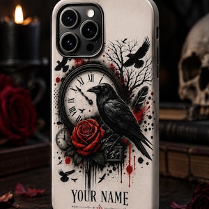 May include: A cream-colored phone case featuring a black raven perched on a clock face with Roman numerals, a red rose, and bare tree branches. The design includes black and red ink splatters and the text YOUR NAME printed in a serif font.