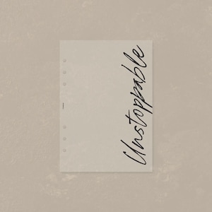 May include: A rectangular beige planner insert featuring six circular punch holes along the left edge and the word Unstoppable written in a black cursive script vertically along the right side. The small text FORMAE is printed near the holes.