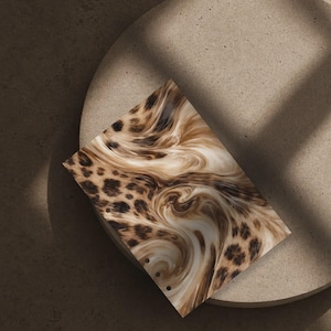 May include: A rectangular planner insert featuring a blended pattern of dark brown leopard spots transitioning into a creamy white and tan marbled swirl design. The left edge contains a vertical row of five circular punched holes for binding.