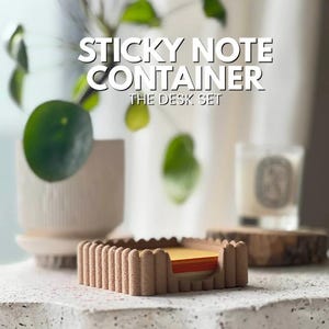 May include: A square, textured, light brown container with a scalloped edge design holding a stack of yellow and orange sticky notes. The text STICKY NOTE CONTAINER THE DESK SET is displayed in white letters above the object.