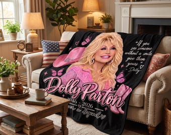 Puede incluir: Una manta negra con un retrato de Dolly Parton, un sombrero de vaquero rosa, botas de vaquero rosas y mariposas. El texto dice: "If you see someone without a smile, give them yours." - Dolly, "Dolly Parton", "1946 - 2026" y "ever a legend".