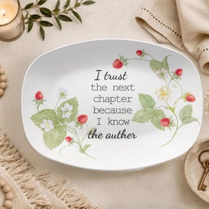 May include: An oval white ceramic serving platter featuring a watercolour illustration of strawberry plants with green leaves, white flowers, and red berries. The centre text reads: I trust the next chapter because I know the auther.