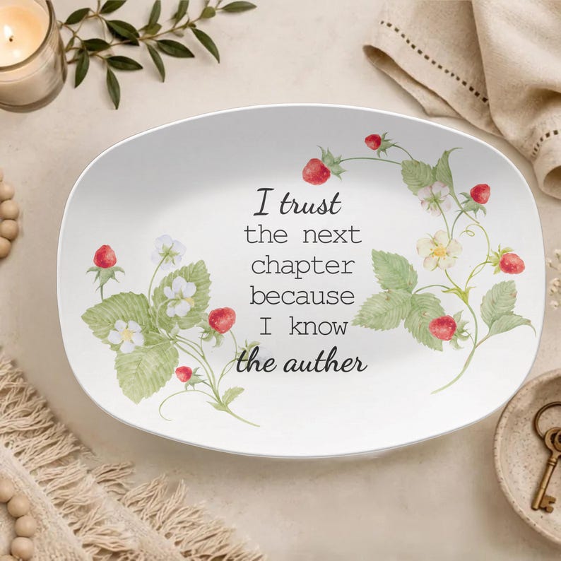 May include: An oval white ceramic serving platter featuring a watercolour illustration of strawberry plants with green leaves, white flowers, and red berries. The centre text reads: I trust the next chapter because I know the auther.