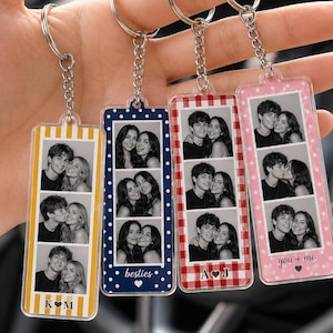 May include: Four rectangular acrylic keychains with silver metal rings and chains. Each keychain features a vertical strip of three black and white photos of a couple, with colorful patterned borders and personalized initials or text at the bottom.