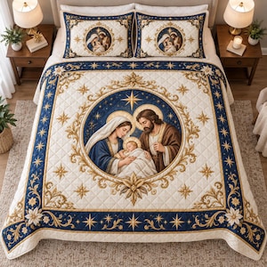 Könnte beinhalten: Eine gesteppte Tagesdecke und zwei passende Kissenbezüge mit einer zentralen kreisförmigen Darstellung der Geburt Christi mit Maria, Josef und dem Jesuskind. Das Design umfasst goldene Ornamente, blaue Ränder und Sternmotive auf cremefarbenem Stoff.