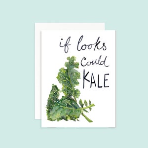 Puede incluir: Una tarjeta blanca con una ilustración de acuarela de un manojo de col rizada verde. La tarjeta tiene texto escrito a mano en negro que dice "if looks could KALE".