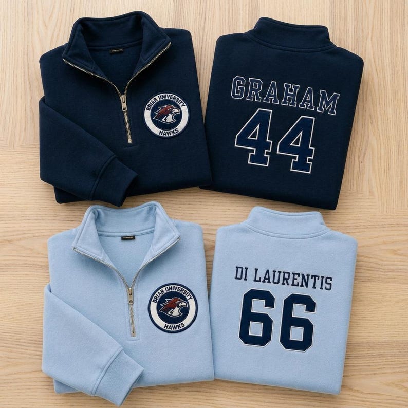 May include: Two quarter-zip sweatshirts in navy blue and light blue. The navy sweatshirt features a Briar University Hawks patch and the name GRAHAM with the number 44. The light blue sweatshirt features the same patch and DI LAURENTIS with 66.