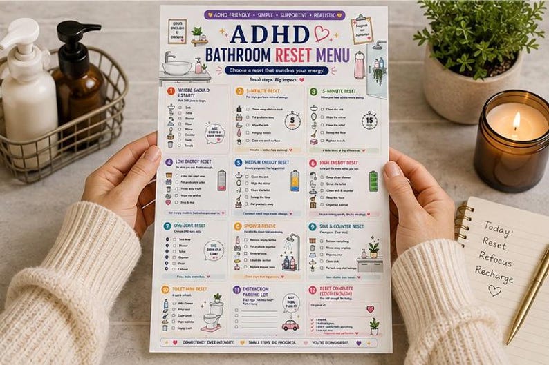 May include: A printed ADHD Bathroom Reset Menu checklist featuring twelve numbered cleaning tasks, icons, and energy-level categories. The document includes text headers like ADHD Bathroom Reset Menu, 5-Minute Reset, and 15-Minute Reset, organized in a grid layout with checkboxes for tracking progress.