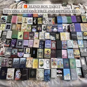 Può includere: Una vasta collezione di scatole rettangolari per carte dei tarocchi disposte a griglia, con diverse illustrazioni colorate, simboli e testo. La parte superiore dell'immagine mostra il testo BLIND BOX TAROT e BUY ONE GET ONE FREE (NO DUPLICATES!).