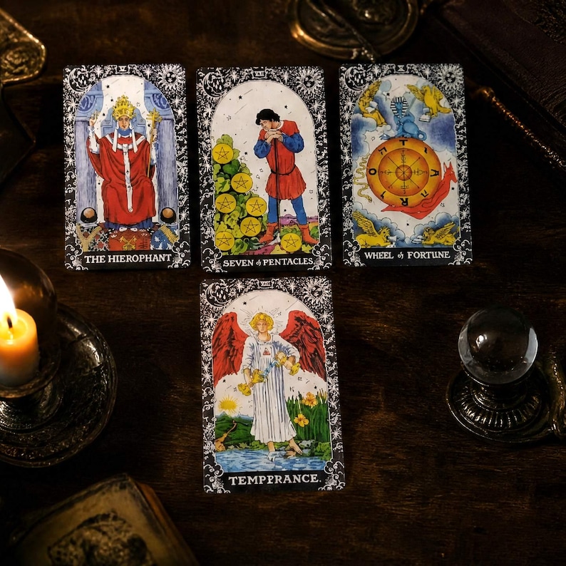May include: Four tarot cards arranged on a dark surface. The top row features The Hierophant, Seven of Pentacles, and Wheel of Fortune. Below them is the Temperance card. Each card displays detailed illustrations with ornate black and white borders.
