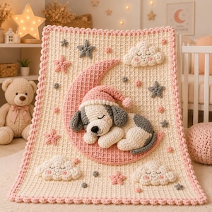 Könnte beinhalten: Eine cremefarbene Häkeldecke mit einem großen rosa Halbmond und einem schlafenden Welpen, der eine rosa Schlafmütze trägt. Die Decke ist mit drei lächelnden weißen Wolken sowie kleinen grauen und rosa Sternen verziert und hat einen rosa Rand.