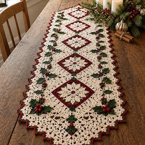 Può includere: Un runner da tavola rettangolare all'uncinetto con un motivo a fiocchi di neve color crema centrato all'interno di bordi a rombo rosso scuro. Il runner è decorato con foglie di agrifoglio verdi e bacche rosse, con bordo smerlato e nappa.