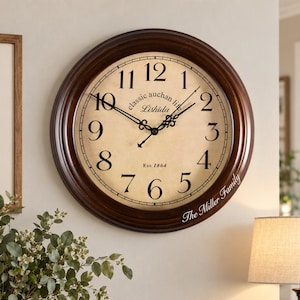 May include: A round wall clock with a dark brown wooden frame and a cream-coloured face featuring black Arabic numerals. The clock face displays the text "classic auchan life", "Lishida", "Est. 1864", and "The Miller Family" with black ornate hands.