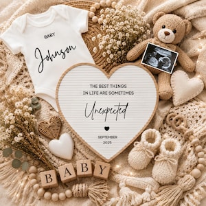 May include: A white baby bodysuit with the text Baby Johnson, a heart-shaped letter board with the text The best things in life are sometimes Unexpected September 2025, a brown teddy bear, an ultrasound photo, knit booties, and wooden blocks.