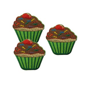 May include: Three embroidered cupcake patches featuring brown frosting, a red cherry on top, and colorful sprinkles. Each cupcake sits in a bright green pleated paper liner with a tan base, showcasing detailed stitching and vibrant thread colors.