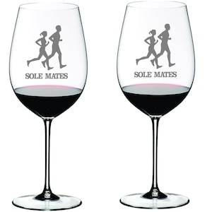 May include: Two clear wine glasses with a design of two running figures and the text "SOLE MATES".