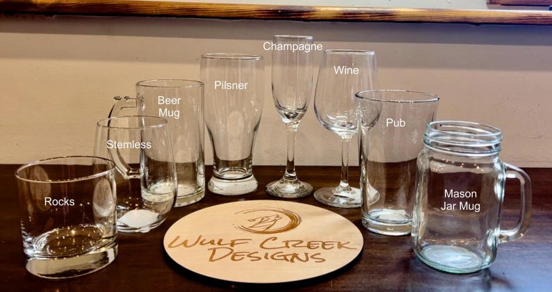 May include: Assortment of clear glass drinking glasses, including a pilsner, beer mug, rocks glass, wine glass, champagne flute, pub glass, and a mason jar mug.