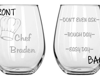 May include: Two clear glass wine glasses with etched designs. The front glass has a chef's hat and the text "Chef Braden". The back glass has the text "Don't even ask", "Rough day", and "Easy day".