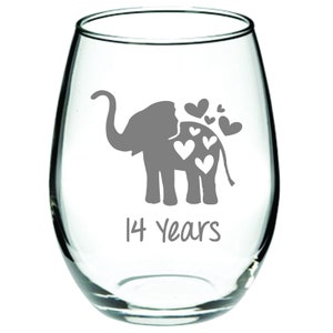 May include: A clear glass wine glass with a gray elephant design and the text "14 Years" on the bottom. The elephant has hearts around it.