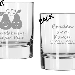 May include: Clear glass tumbler with a wide base. The front features two smiling pear illustrations with the text "We Make the Perfect Pear." The back of the glass is engraved with the names "Braden and Karen" and the date "1/21/21."