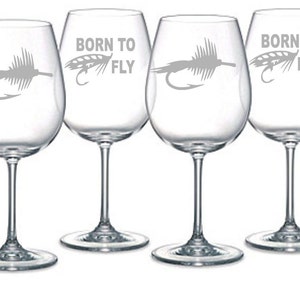 May include: Set of four clear glass wine glasses with a fly fishing lure design and the text "Born to Fly".