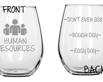 Può includere: Un bicchiere da vino in vetro trasparente con la scritta "HUMAN RESOURCES" e un'immagine stilizzata di tre persone sul davanti. Il retro del bicchiere ha la scritta "DON'T EVEN ASK", "ROUGH DAY" e "EASY DAY".