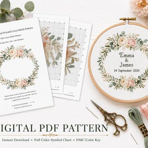 May include: A digital PDF cross stitch pattern featuring a floral wreath design, including printed charts and a finished embroidery hoop with the text Emma & James 14 September 2026, accompanied by vintage-style scissors and three skeins of embroidery floss.
