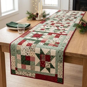 May include: A rectangular quilted table runner featuring a patchwork design of stars and geometric squares in shades of red, green, and cream. The fabric displays various patterns including holly leaves, small checks, and floral motifs with a red border.