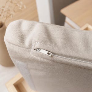 Close-up of the soft zippered cushion fabric on a handmade wall mounted cat bed.