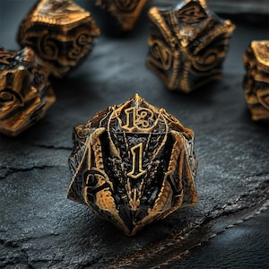 May include: A twenty-sided die featuring a dark black base with metallic gold highlights. The surface is sculpted with intricate dragon-like scales and wing textures. The numbers are embossed in a bold, stylized font, with the number one prominently displayed on the front face.