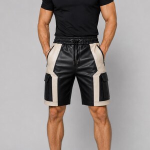 Könnte beinhalten: Schwarze und beige Cargo-Shorts aus Kunstleder mit Color-Block-Design, elastischem Bund mit schwarzem Kordelzug, zwei seitlichen Reißverschlusstaschen sowie zwei großen seitlichen Cargotaschen mit Klappen an den äußeren Beinpartien.