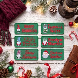 Puede incluir: Seis parches rectangulares verdes bordados con personajes festivos y nombres. Los parches muestran nombres bordados que incluyen a Henry Robinson, Isabella White, Elijah Brown, Evelyn Martin y Jackson Walker en texto rojo.