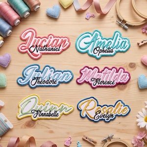 May include: Six embroidered name patches featuring layered script and print text. The patches display the names Lucian Nathaniel, Amelia Ophelia, Julian Theodore, Matilda Florence, Quinn Finnabelle, and Rosalie Evelyn in various colors including pink, blue, green, and gold.