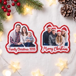 May include: Two custom photo ornaments with red stitched borders. The left ornament shows a family of three with the text Family Christmas 2026. The right ornament shows a family of four wearing Santa hats with the text Merry Christmas.