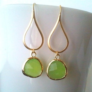 Puede incluir: Pendientes de gota de oro con detalles de piedras preciosas verde claro.