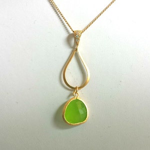 Puede incluir: Un collar de cadena de oro con un colgante en forma de l&aacute;grima. El colgante tiene una piedra preciosa verde y una forma de l&aacute;grima dorada m&aacute;s peque&ntilde;a en su interior.