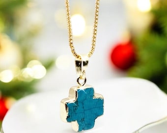 May include: A gold chain necklace with a turquoise cross pendant. The cross is a simple design with a slightly textured surface.
