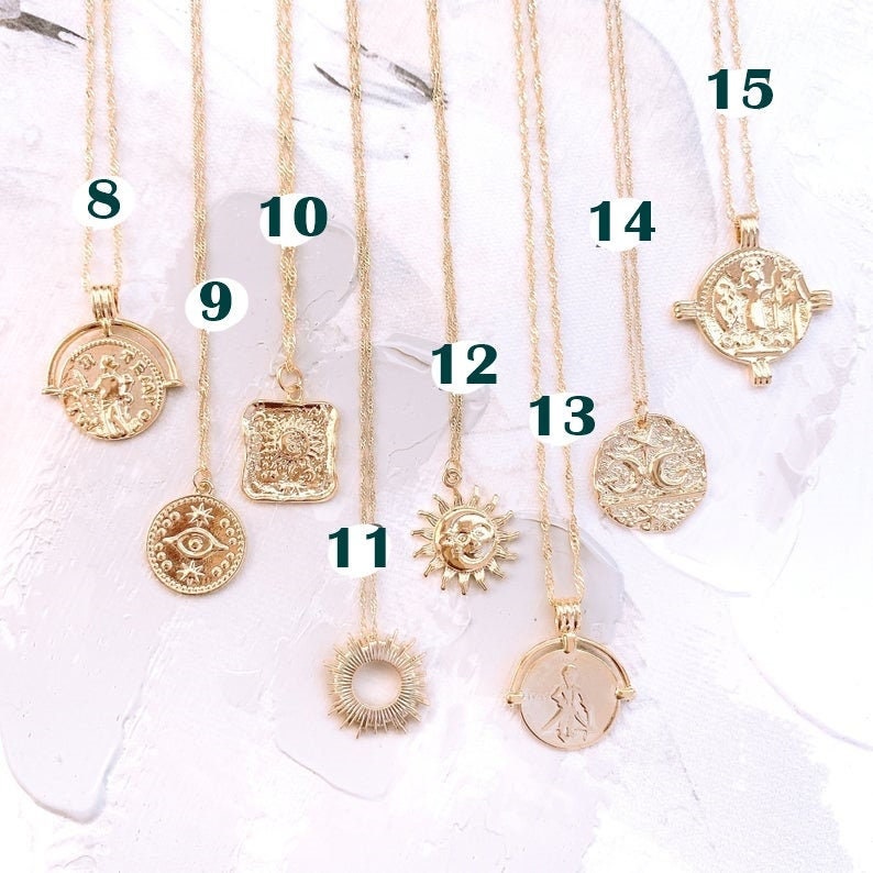 May include: A set of 10 gold necklaces with different pendants, including a sun, a moon, an eye, and a square. The necklaces are numbered 8 through 15.