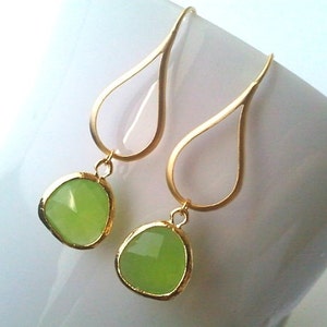 Puede incluir: Pendientes de gota de oro con detalles de piedras preciosas verde claro.
