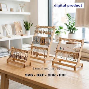 Könnte beinhalten: Drei helle Holzständer für Schmuck und Schlüsselanhänger mit mehreren horizontalen Stangen und Haken. Der Text "digital product", "3 mm, 4 mm, 1/8", 1/6" und "SVG - DXF - CDR - PDF" ist auf dem Bild zu sehen.